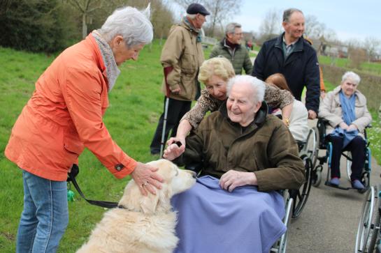 Een vrijwilliger op wandel met een bewoner van WZC Yserheem