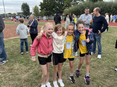 Enkele vriendinnen staan breed glimlachend arm in arm na een inspanning.