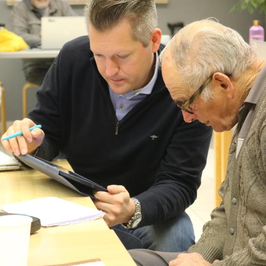 Een vrijwilliger van de digibank helpt een burger met digitale vragen