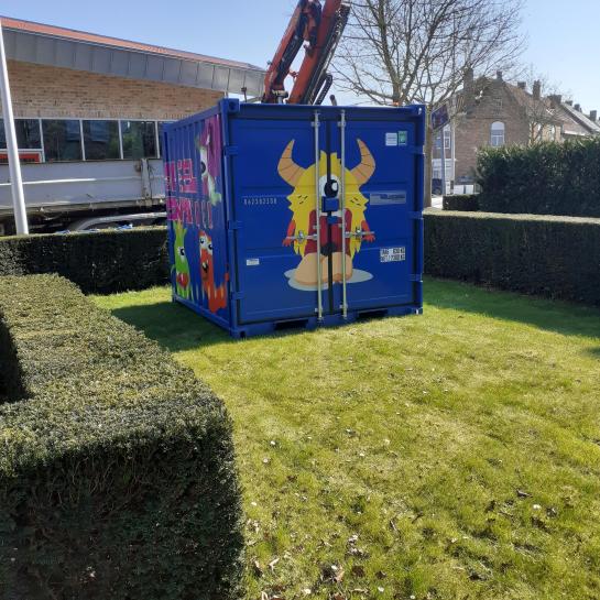 Container met speelgoed in grasveld bij OC Pervijze